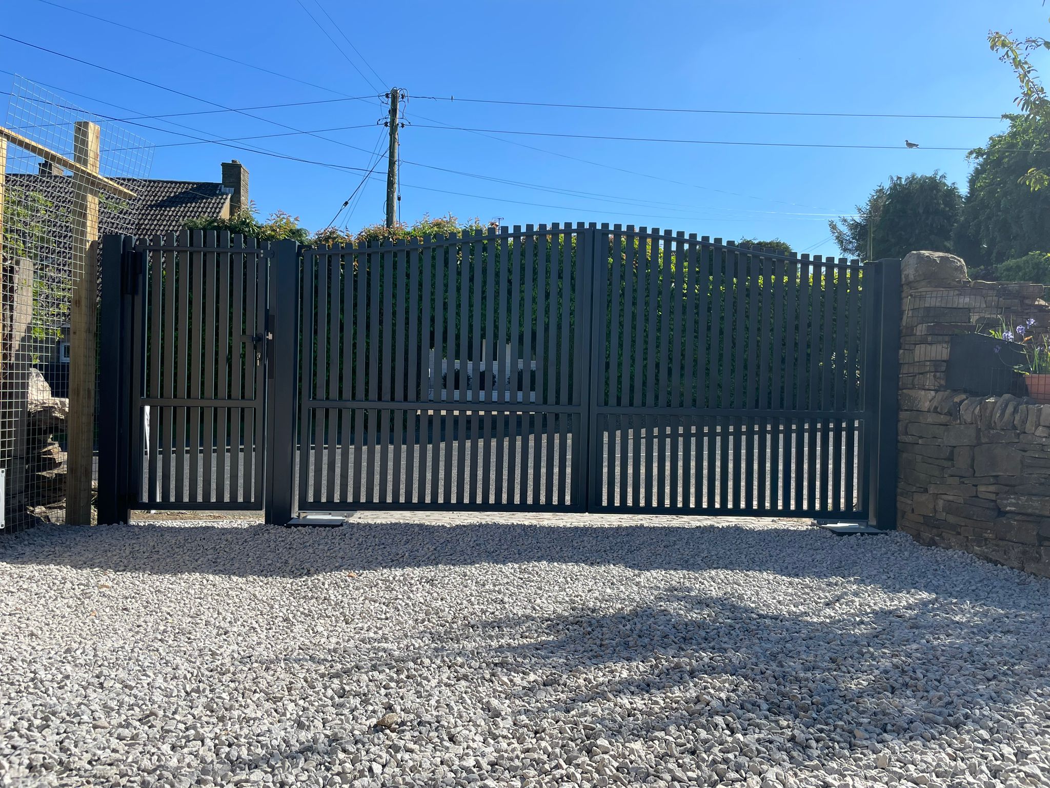 This image shows an automated double swing gate, with pedestrian gate.