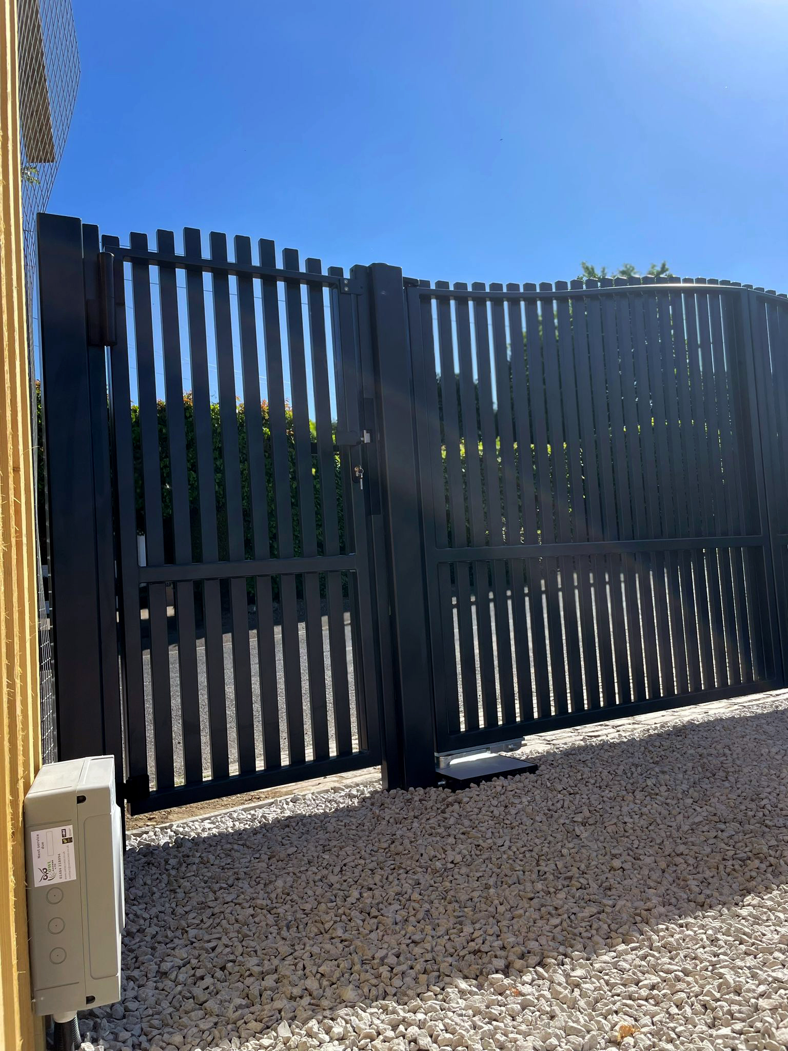 This image shows an automated double swing gate, with pedestrian gate.