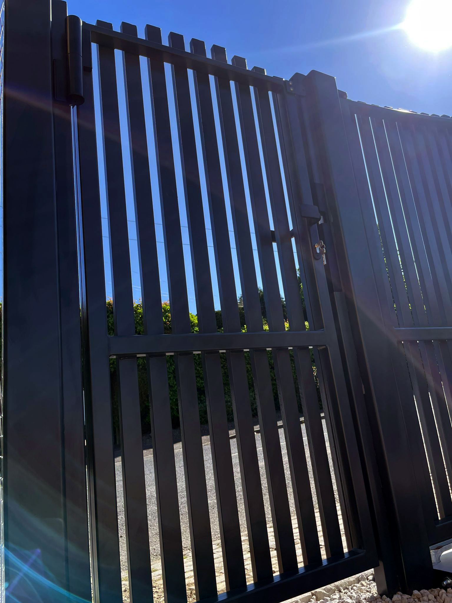 This image shows an automated double swing gate, with pedestrian gate.