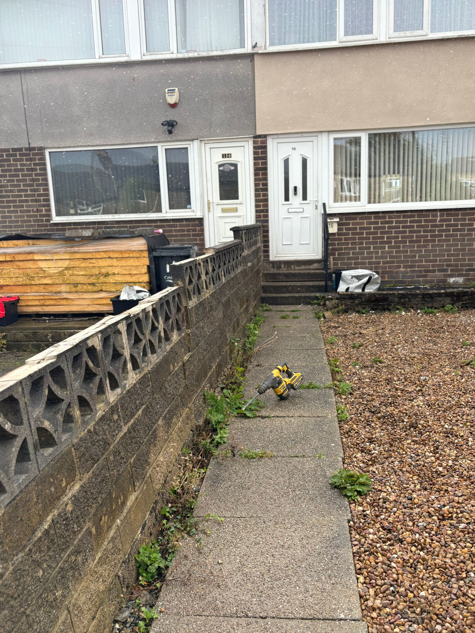 This image shows an old wall, ready to be replaced with a new composite fence.