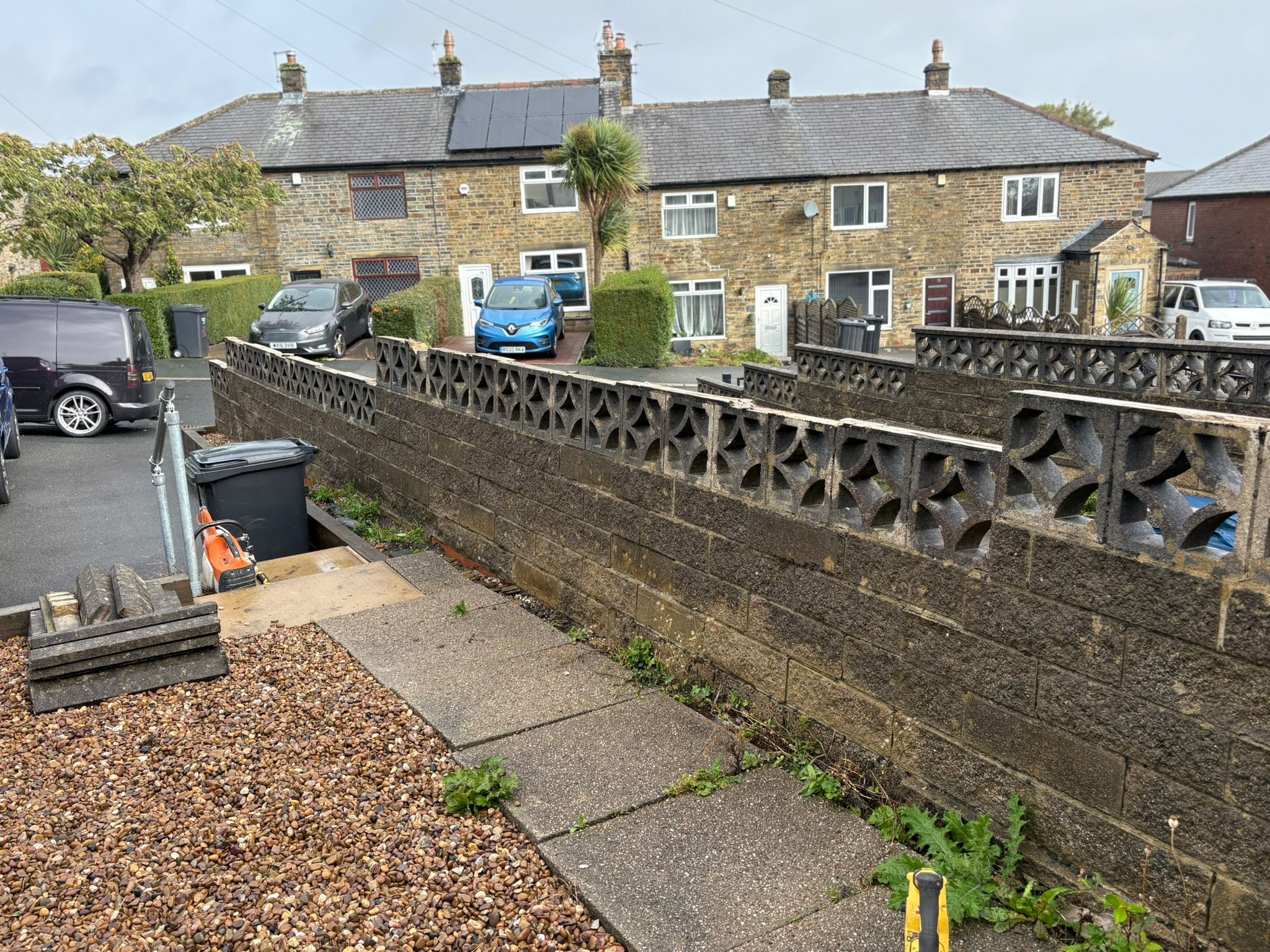 This image shows an old wall, ready to be replaced with a new composite fence.