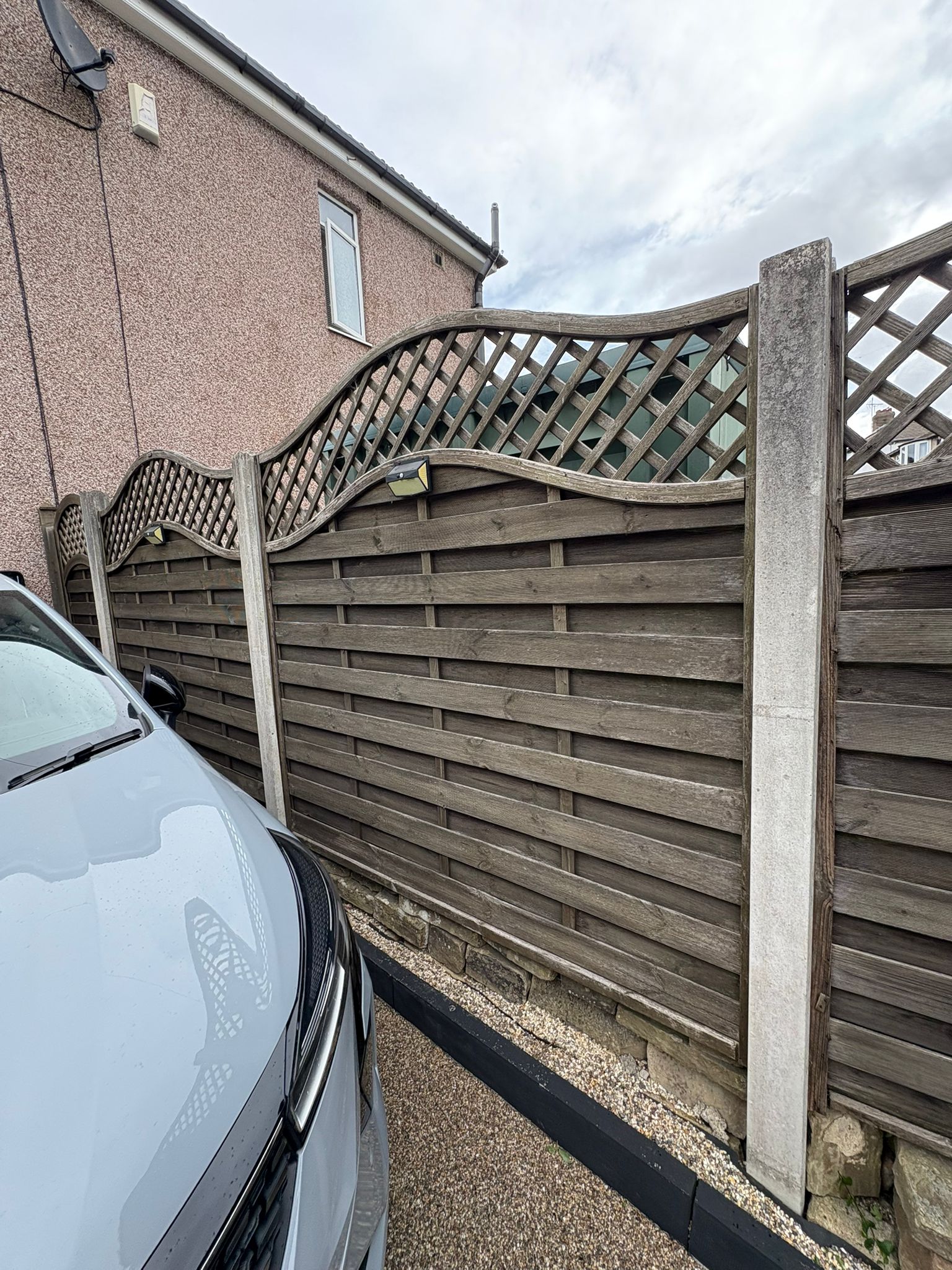 This image shows an old fence, ready to be upgraded to a new composite fence.